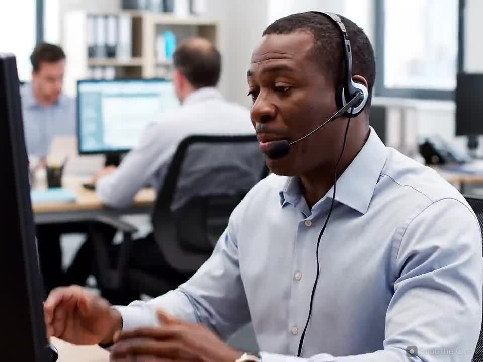 A support agent in a headset helping a customer on a call.