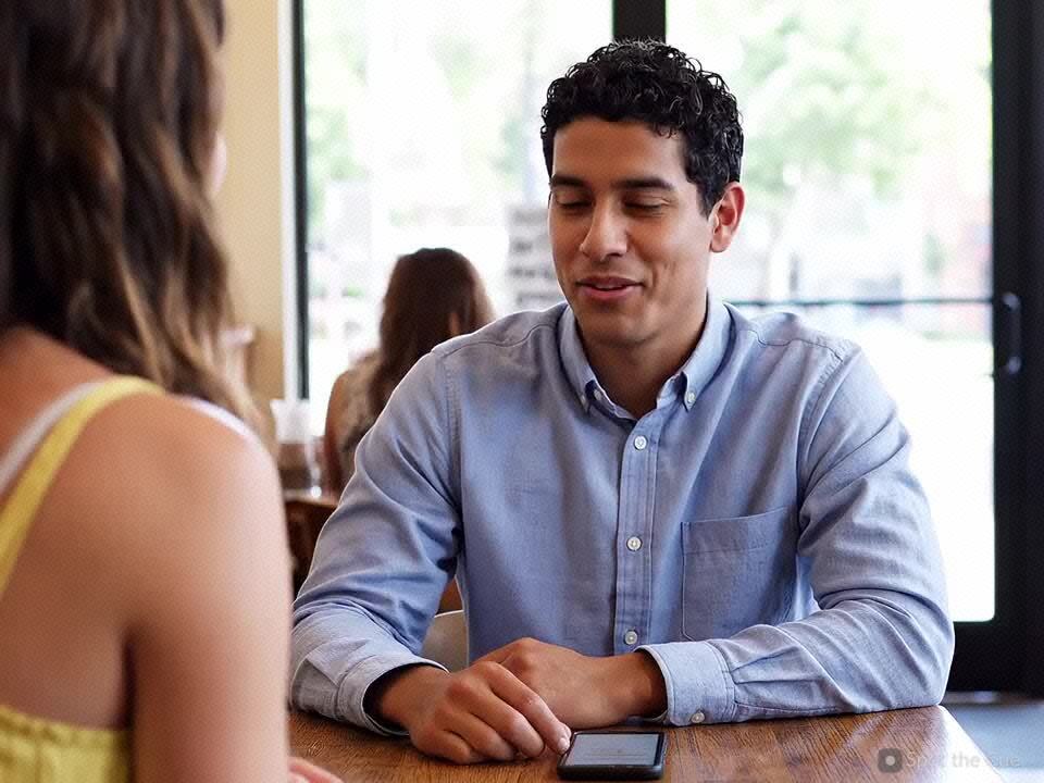 A person at a café glancing down at their phone.