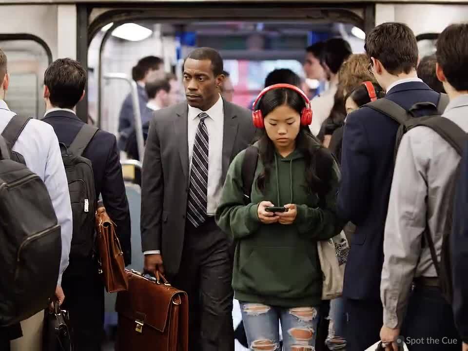 People stepping aboard a subway train at a station.